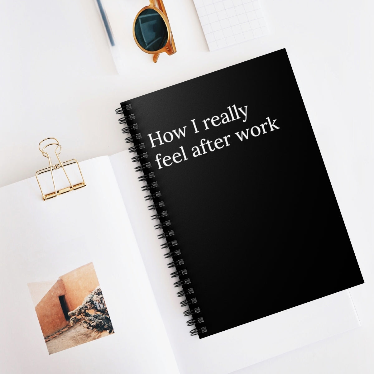 black covered paper notebook with the words How I really feel after work written on the front and photos surrounding it