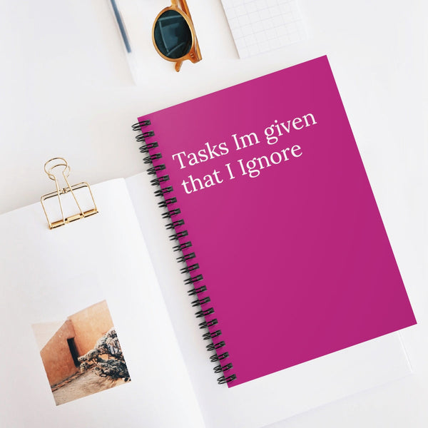 A spiral notebook with a pink cover, titled 'Tasks I'm given that I Ignore'.