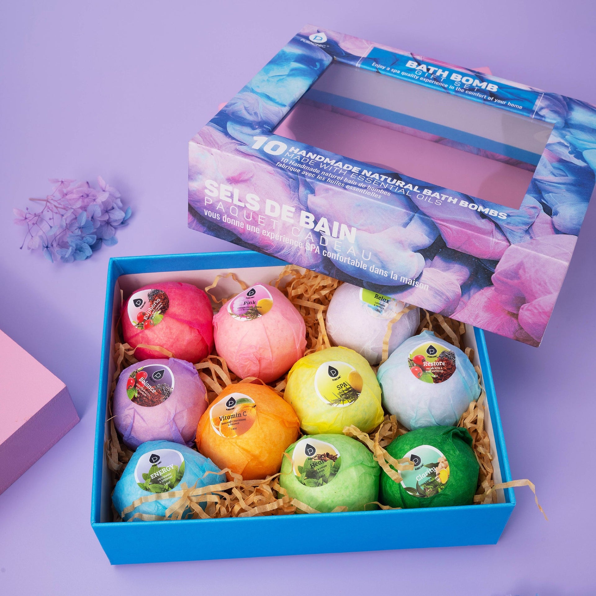 Box of colorful bath bombs with a visible brand name on a purple background