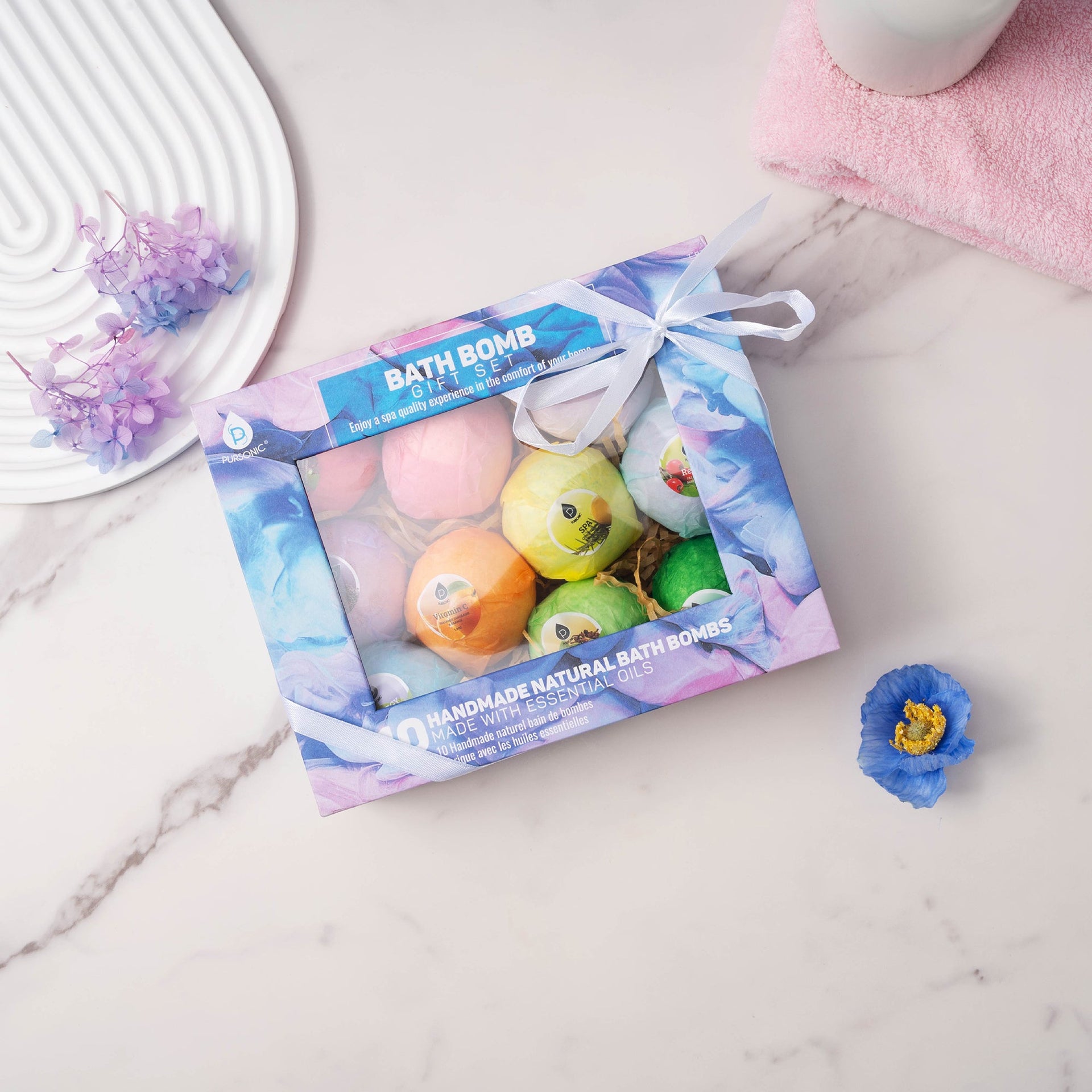 Box of bath bombs with colorful packaging on a marble surface.
