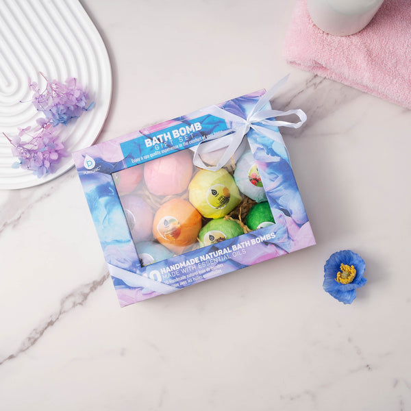 Box of bath bombs with colorful packaging on a marble surface.
