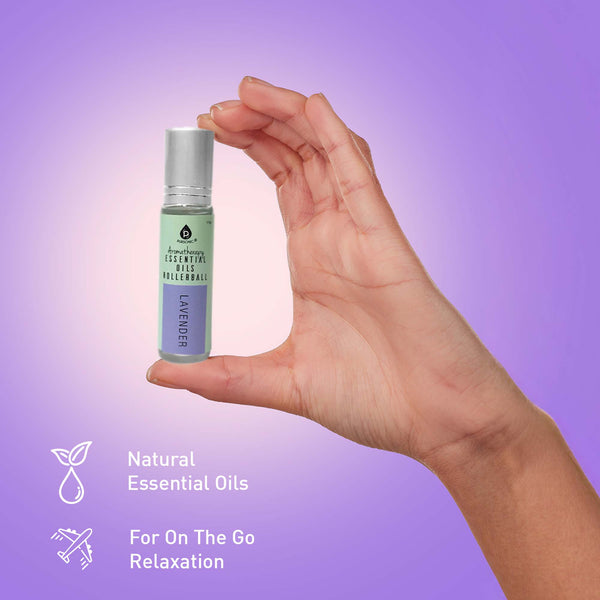 Hand holding a small bottle of essential oils with a purple gradient background
