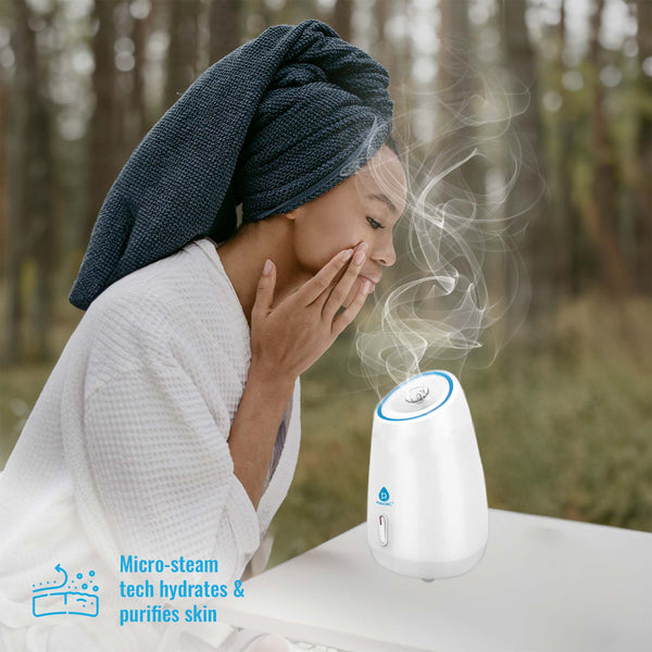 Woman with a towel on her head using a humidifier with steam, outdoors.