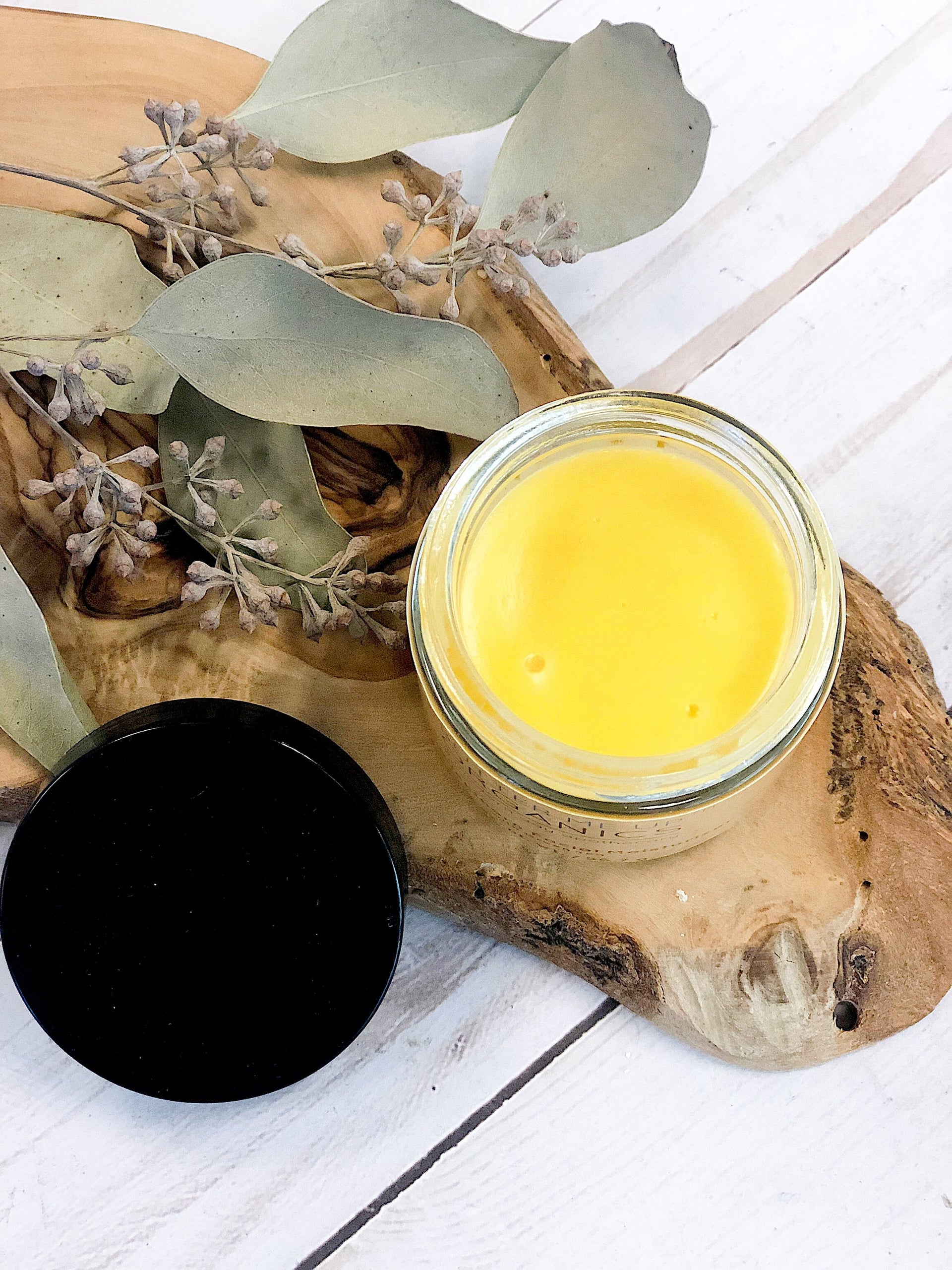 butter me up organics sea buckthorn facial moisturizer on a piece of wood