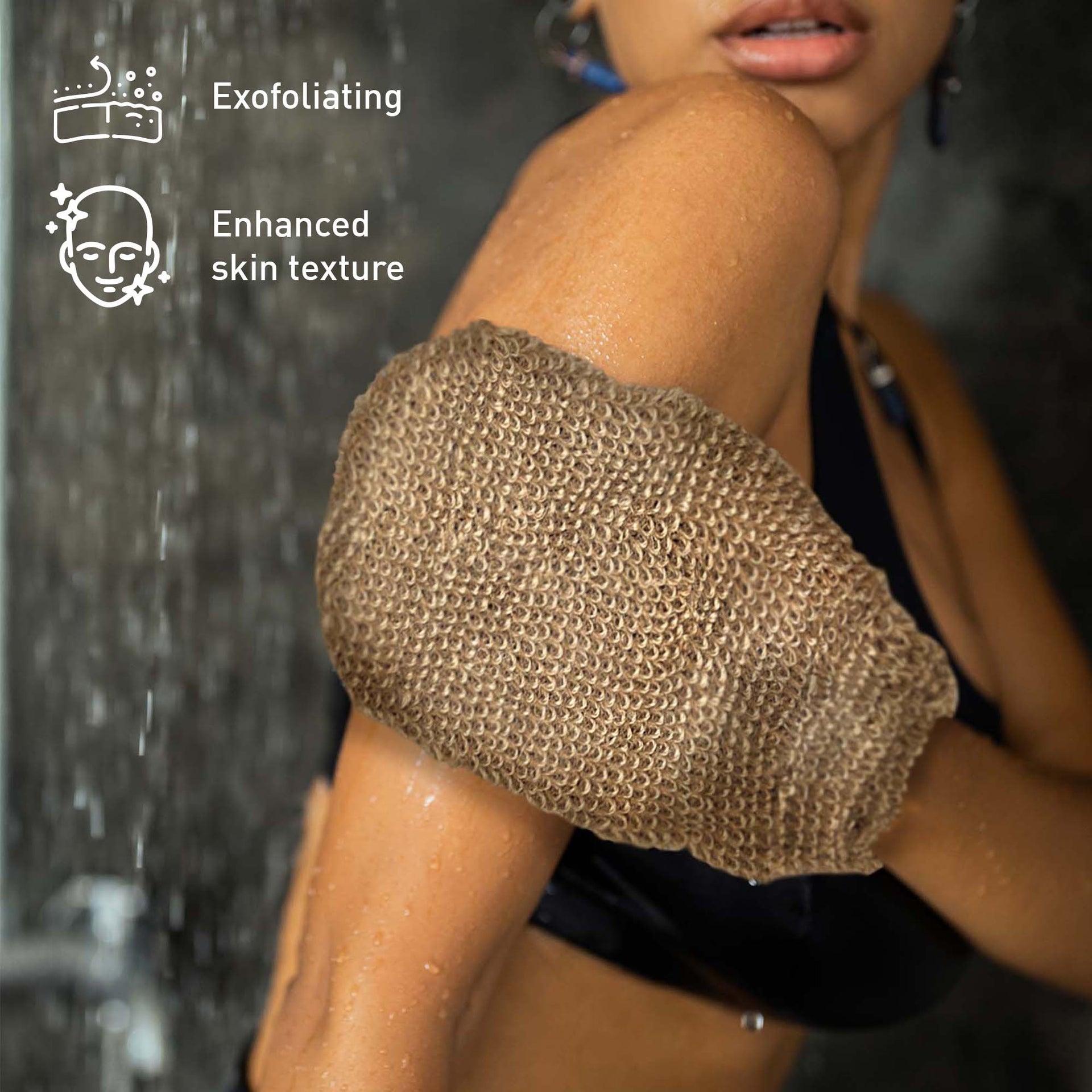 Person using a exfoliating glove with shower water in the background