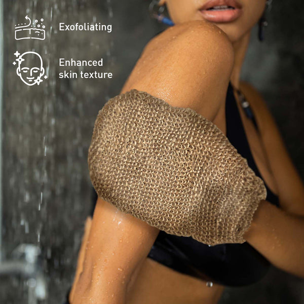 Person using a exfoliating glove with shower water in the background