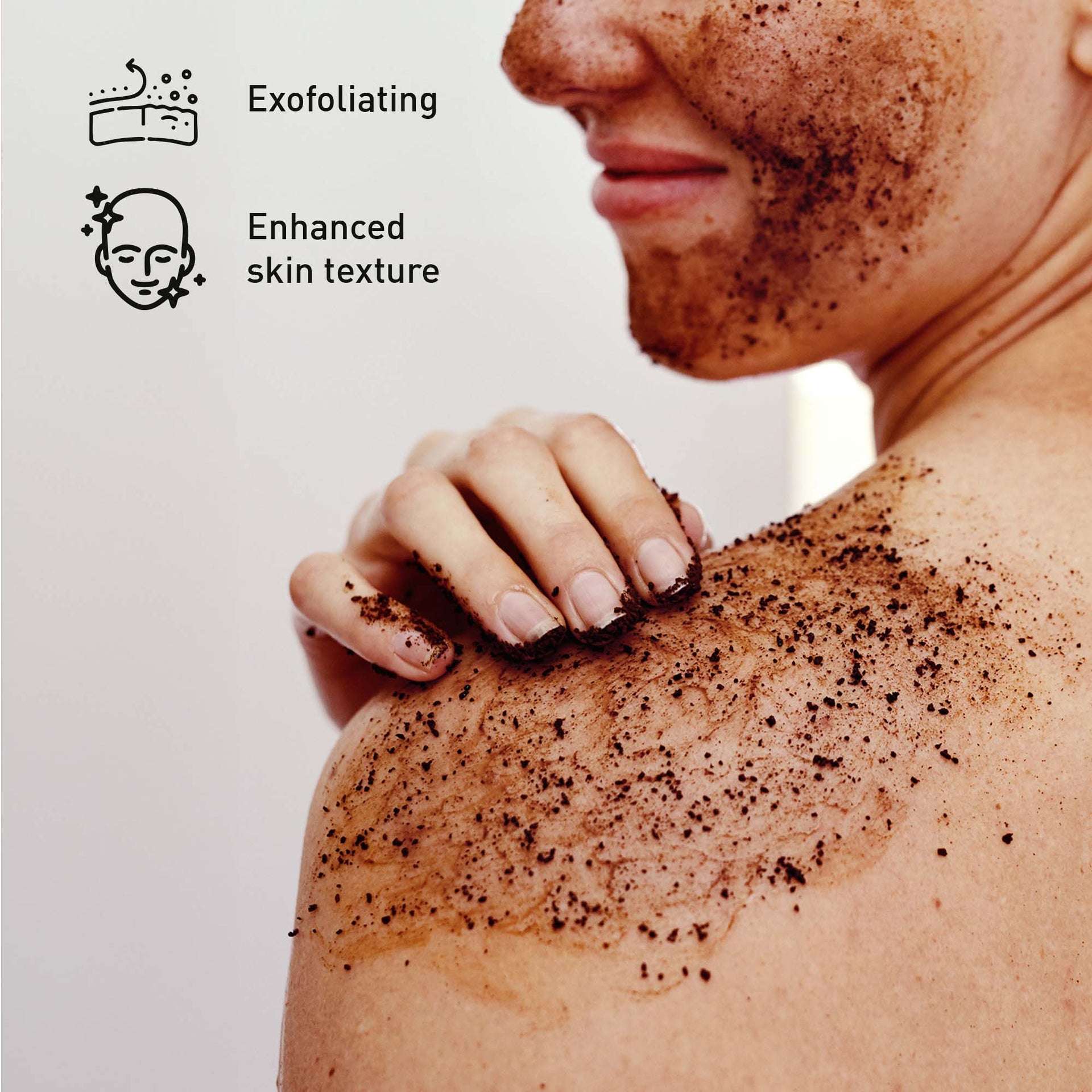 Person exfoliating their shoulder with a scrub, with text indicating 'Exfoliating' and 'Enhanced skin texture'.