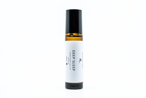 deep sleep essential oil roll on in a glass amber bottle with a black cover