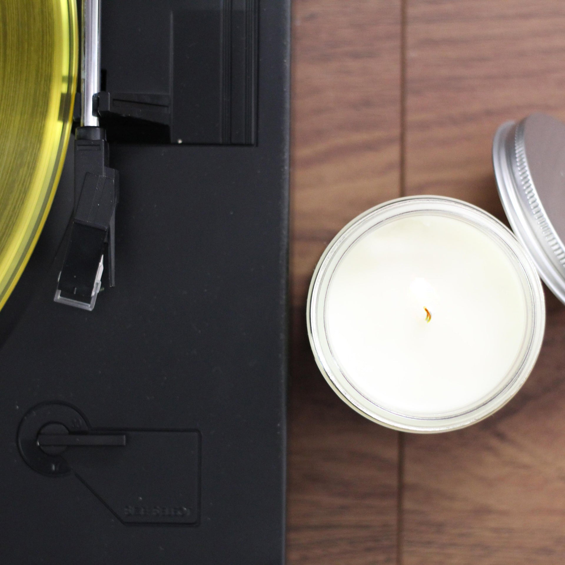 white candle next to a record player