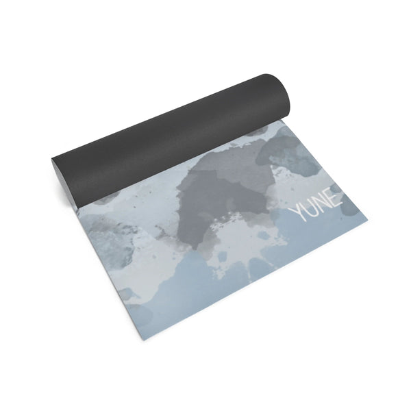 Yoga mat with black top and gray patterned bottom on a white background
