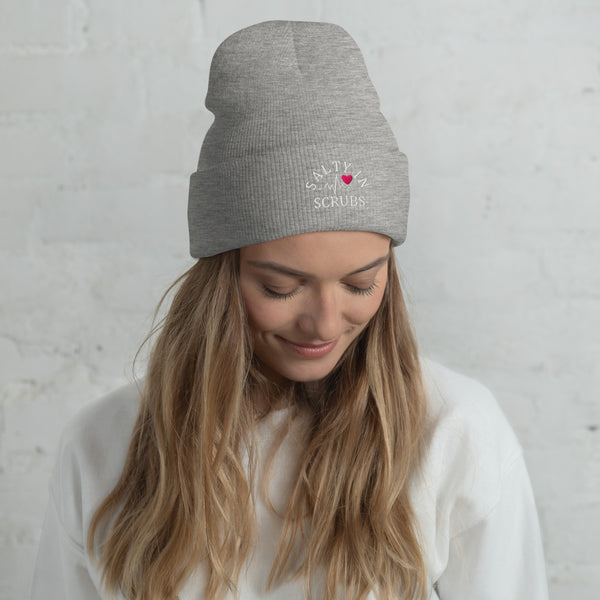 Product photo of light grey winter hat with salty in scrubs logo on a woman's head