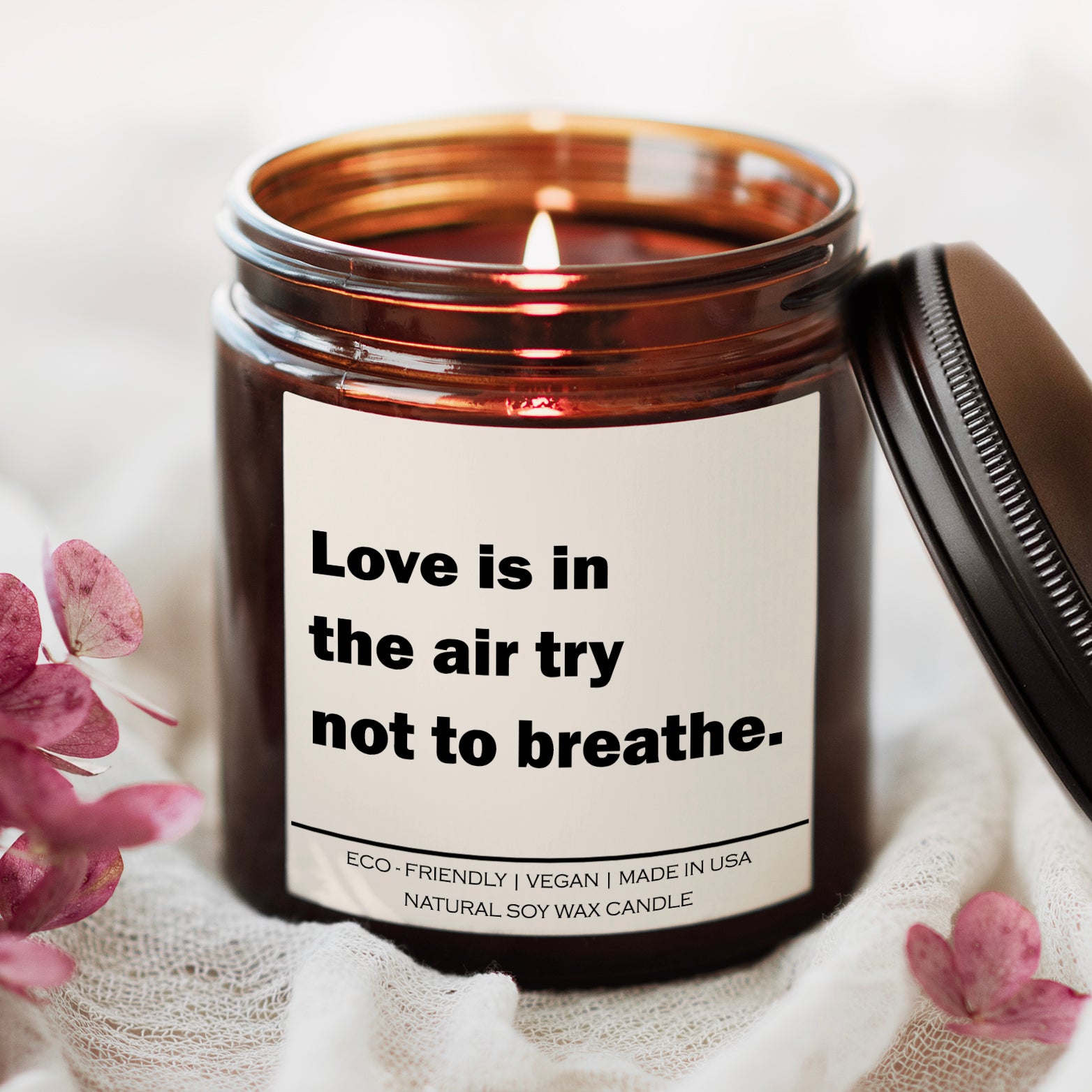 Love Is In The Air Try Not To Breathe candle in amber glass jar with white label, humorous lung disease and respiratory-themed soy candle for self care and awareness