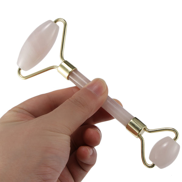 a hand holding the rose quartz facial massager with dual head massagers