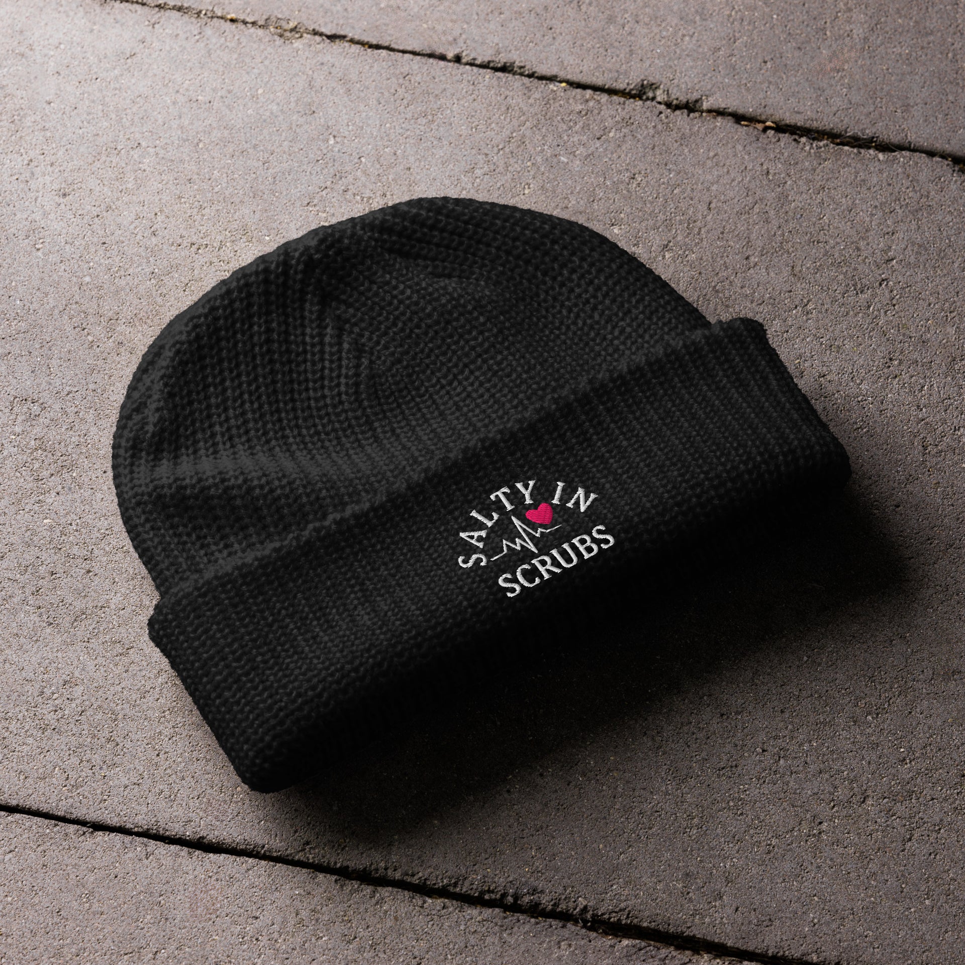 Product mockup of a black fisherman cap with salty in scrubs logo embroidered on the front